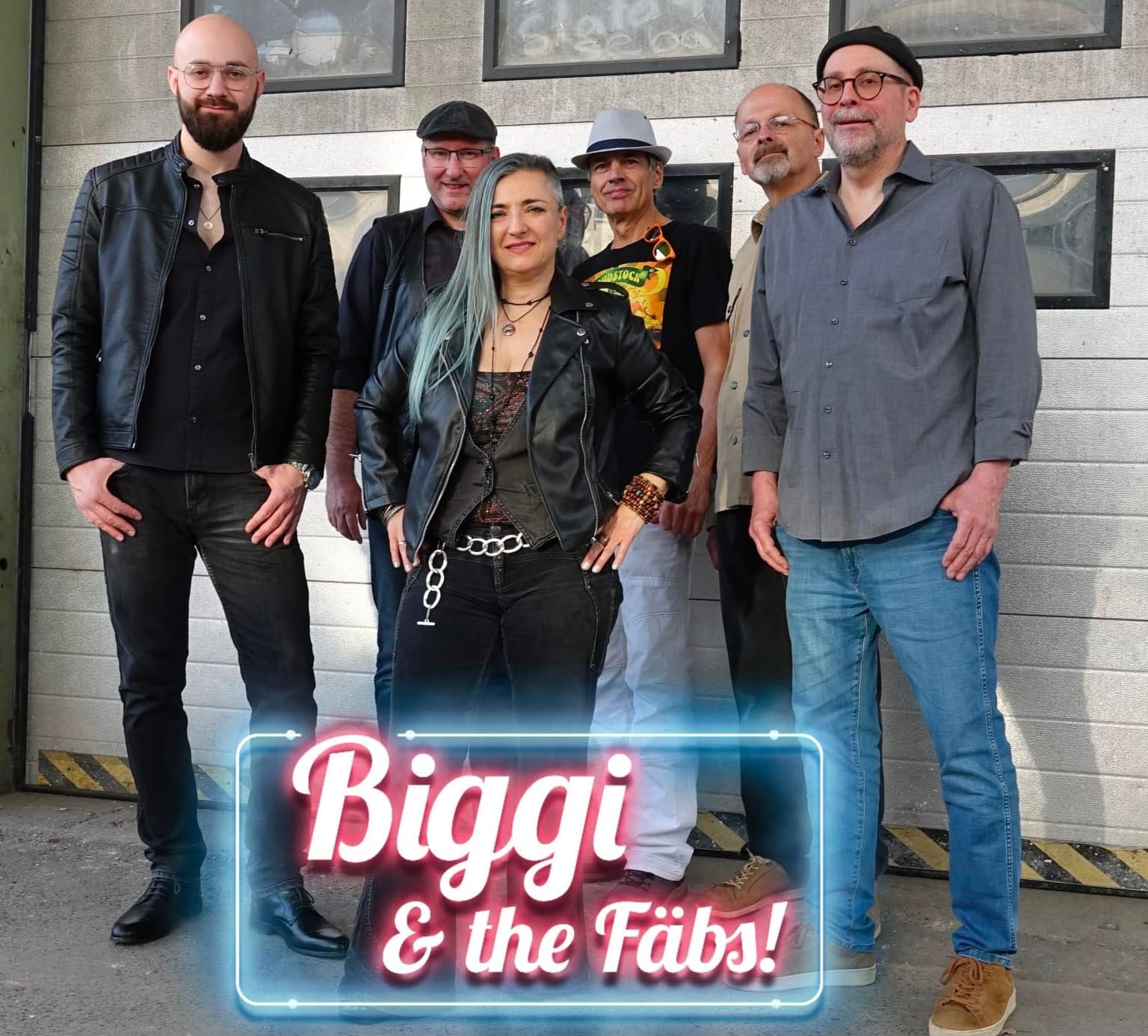 Bandfoto von Biggi & the Fäbs!: alle sechs Mitglieder vor einem Garagentor, Biggi in der Mitte, unten der Neonschriftzug der Band
